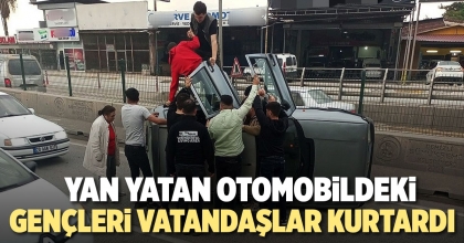 YAN YATAN OTOMOBİLDEKİ GENÇLERİ VATANDAŞLAR KURTARDI  